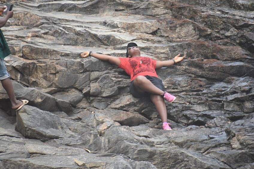 A person lying on rocks with arms outstretched. 3