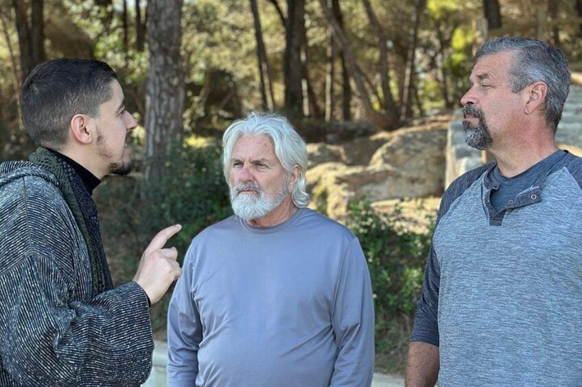 Three people standing outdoors in a wooded area. 4