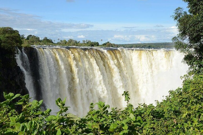Una cascada grande rodeada de abundante vegetación. 4