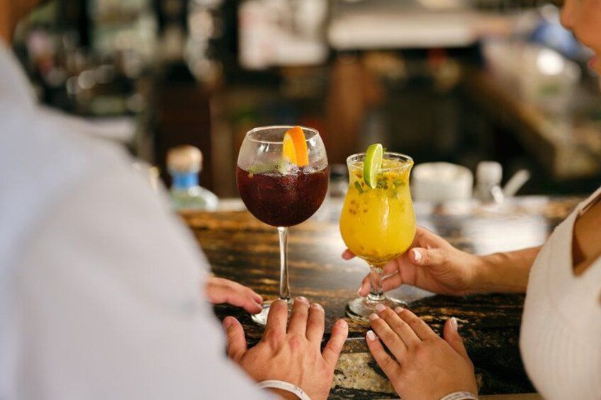 Two people at a bar with drinks in front of them. 5