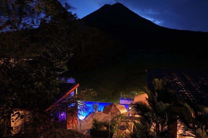 A mountain at dusk with illuminated structures and vegetation. 4