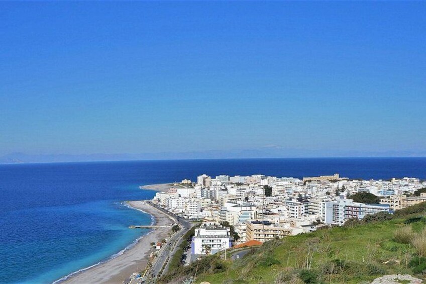 Une ville côtière avec des bâtiments qui bordent la plage et un ciel bleu dégagé. 3