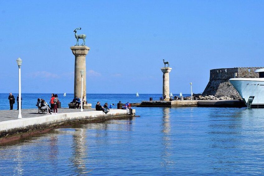 Une promenade en bord de mer, agrémentée de deux imposantes colonnes surmontées de statues, et avec un fort historique en arrière-plan. 5