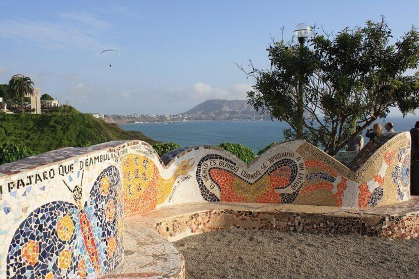 A mosaic wall with a view of the sea and a tree. 5