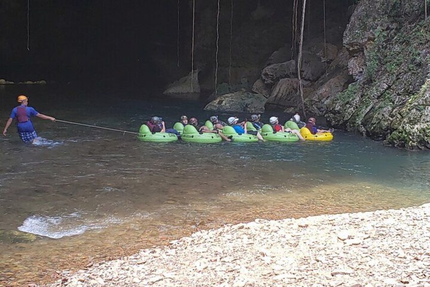 A group of people rafting in green and yellow boats on a river. 2