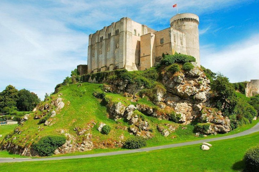 A castle on a hill with a flag, surrounded by greenery and a clear sky. 2