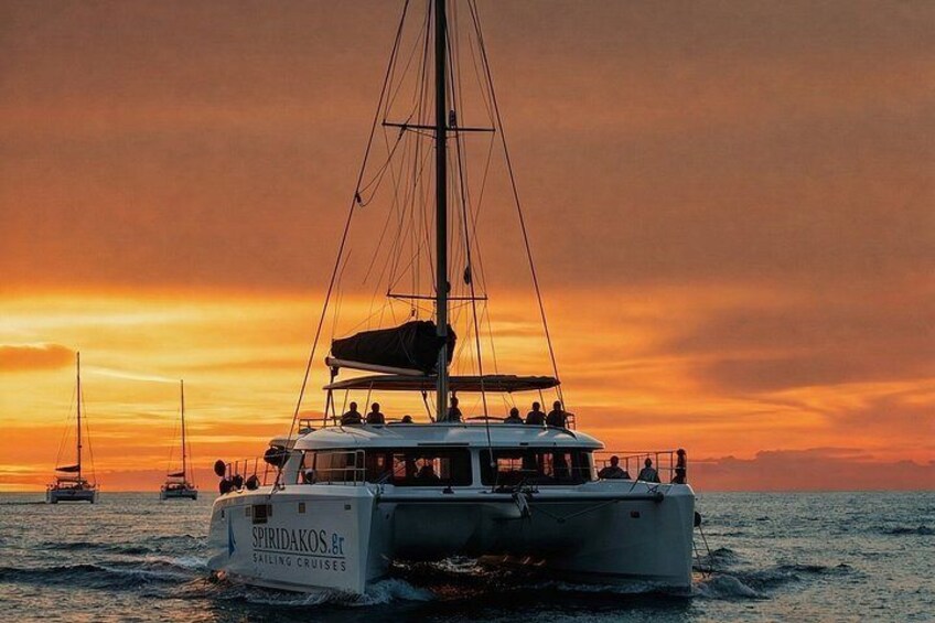 Ein Segelkatamaran mit Passagieren vor einem Sonnenuntergangshimmel. 3