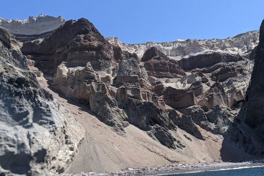 Rocky formations at Mesa Pigadia. Explore the stunning Santorini coastline on our catamaran! Discover hidden gems and create unforgettable memories on the Aegean Sea. 3