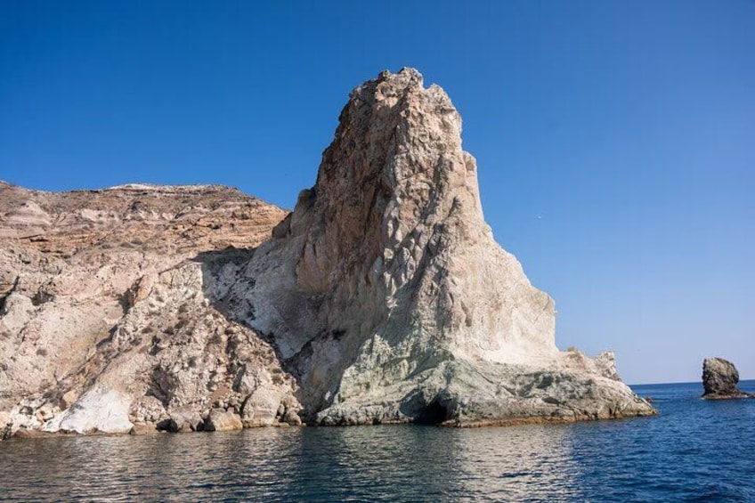 A rocky coastal landscape with a prominent rock formation and calm sea. 3