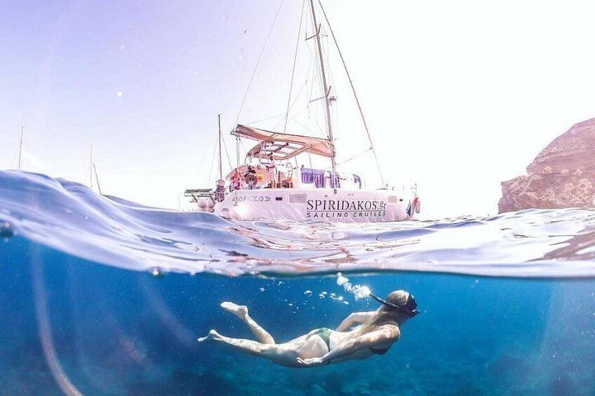 Eine Person schwimmt unter Wasser, im Hintergrund ein Segelboot. 4