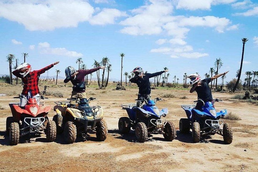 Three people on ATVs in a dry, open landscape with palm trees. 5