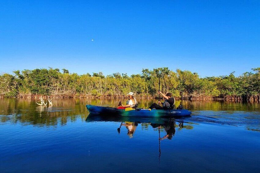 A calm river with a canoe carrying two people. 4