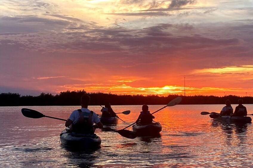 A group of kayakers on a calm lake during sunset. 5