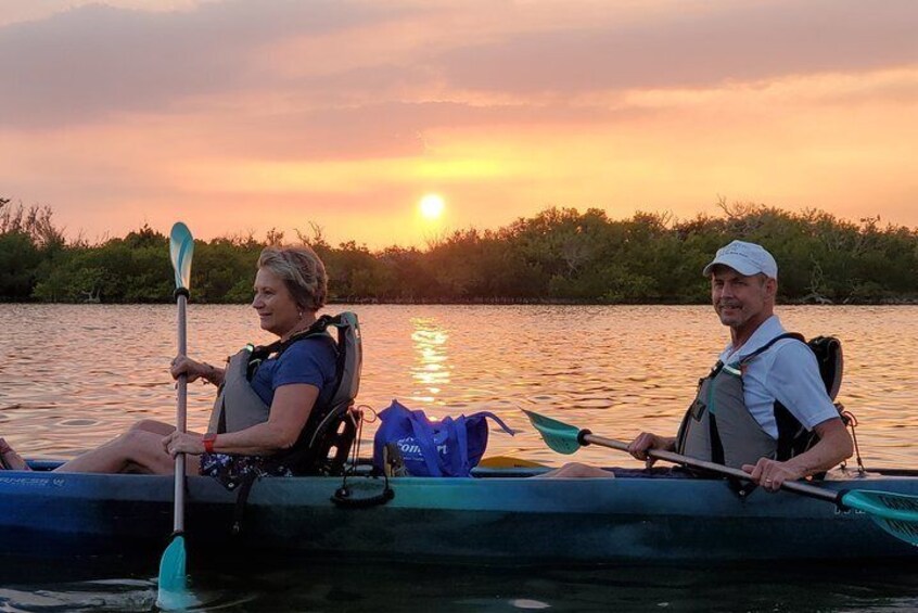 Two people kayaking on a calm river at sunset. 5