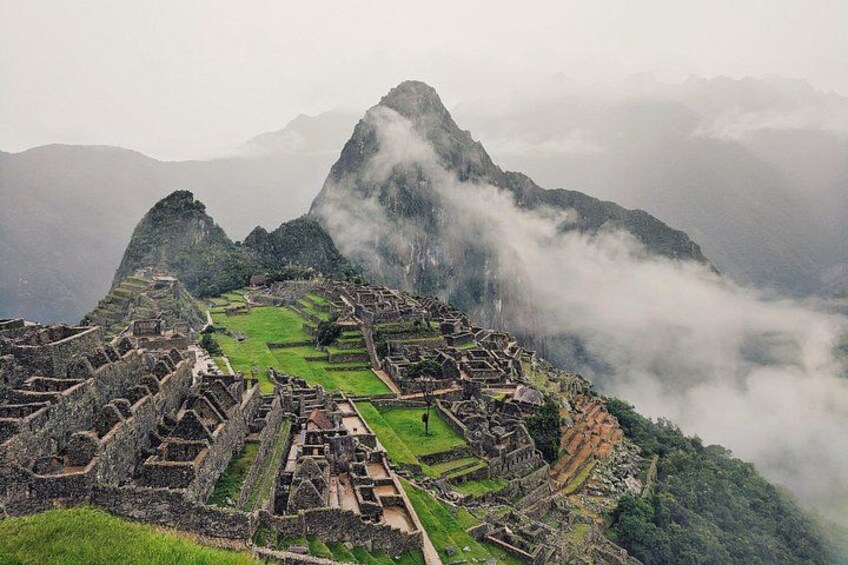 Machu Picchu ruins with Inca stone walls and terraces, surrounded by misty mountains. 1