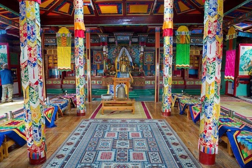 A colorful interior with ornate pillars, patterned rugs, and traditional decor. 2