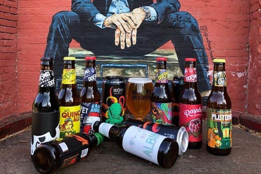 Variedad de botellas y latas de cerveza frente a un mural. 1