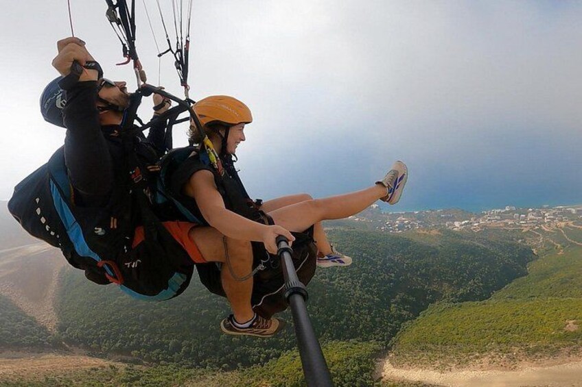 A person paragliding with a harness and helmet, overlooking a mountainous landscape. 2