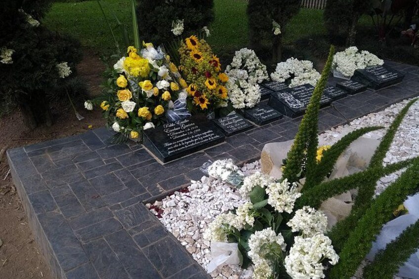 Un cementerio con lápidas, flores y césped bien cuidado. 3