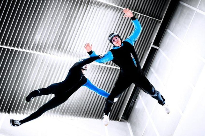 A person in a blue and black suit performing a jump. 1