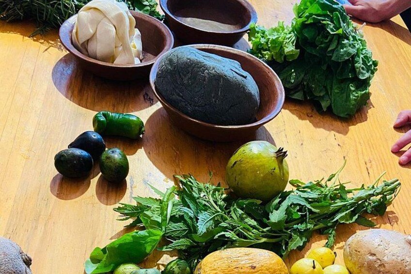 A variety of fresh vegetables and herbs on a wooden table. 4