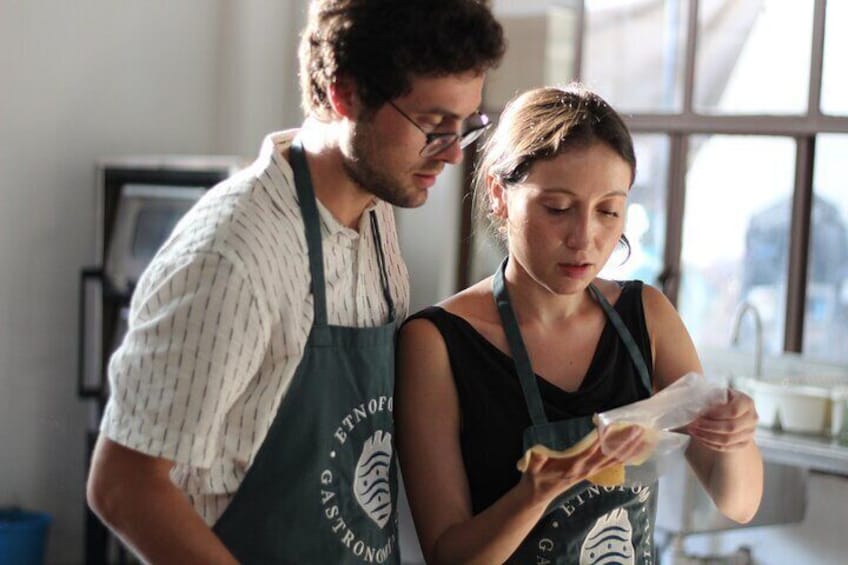 Two people in a kitchen, one holding a lemon. 2
