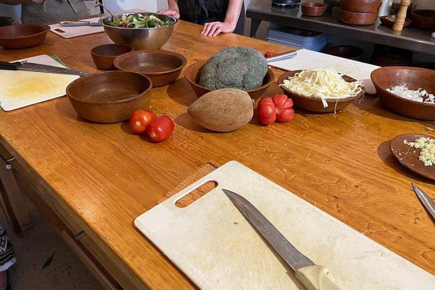 A wooden cutting board with a knife, bowls of vegetables, and a person in the background. 5