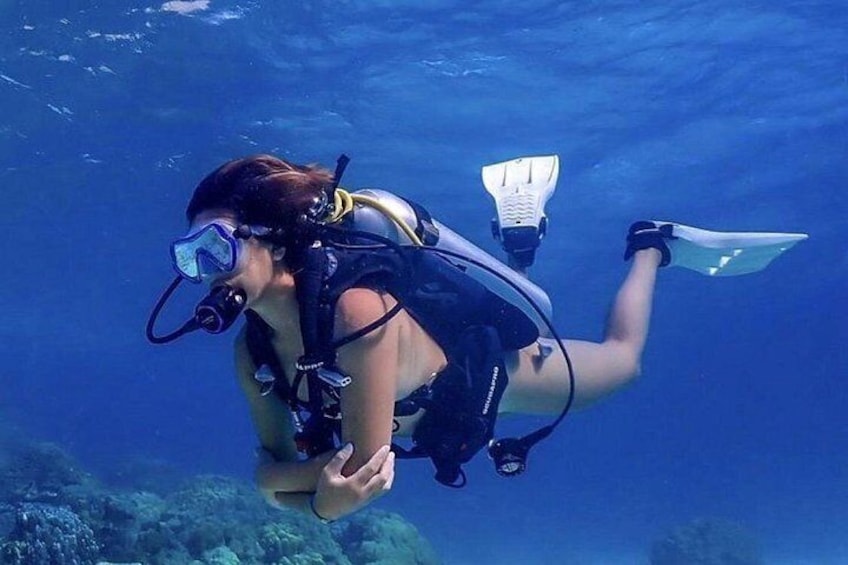 Een duiker snorkelt onder water met vinnetjes en een duikmasker. 2