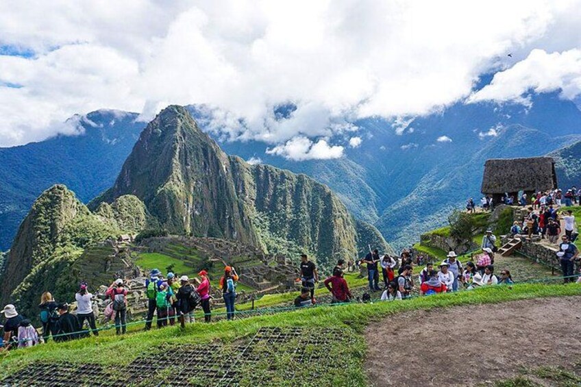 A group of people at Machu Picchu, with a prominent mountain in the background. 5