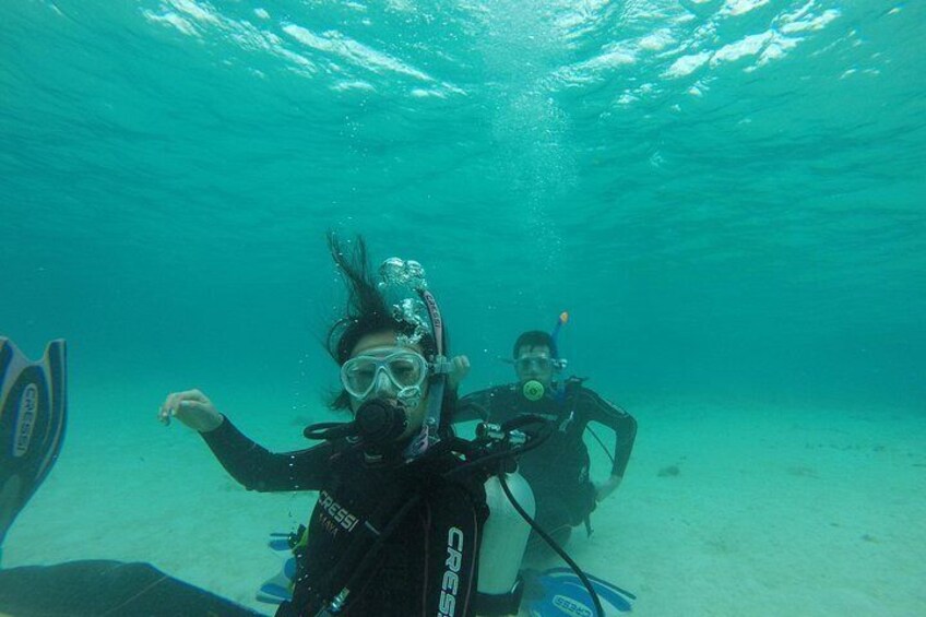 Two scuba divers underwater with fins and tanks. 5