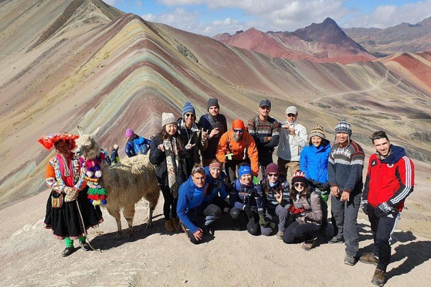 Un grupo de personas con un llama en un paisaje montañoso. 2
