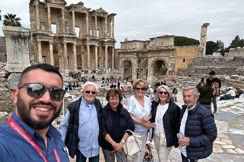 A group of people standing in front of ancient ruins with columns and arches. 3