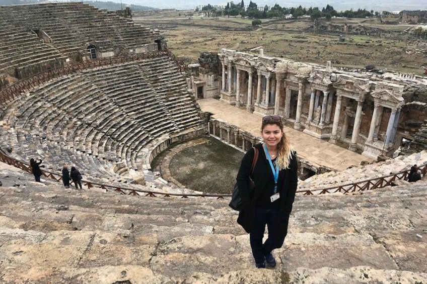 An ancient amphitheater with ruins and columns in the background. 4
