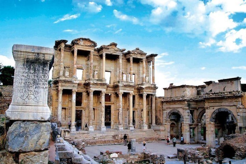 An ancient ruin with columns and a large stone inscription. 1
