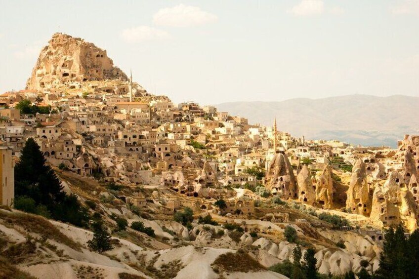 A town built on a hillside with distinctive rock formations and traditional architecture. 3