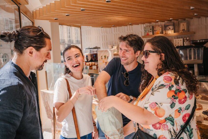 A group of people in a café with wooden ceiling and shelves in the background. 1