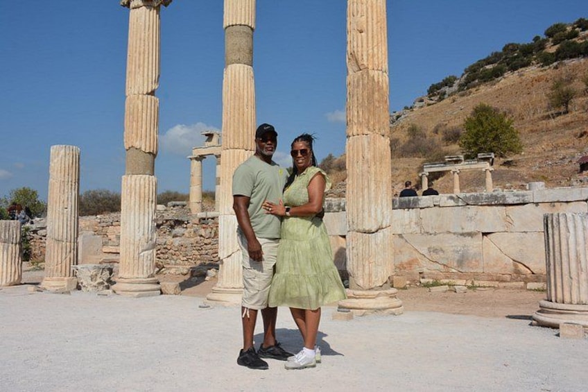 Ancient stone columns, a person in a green dress, and a person in a green shirt. 4