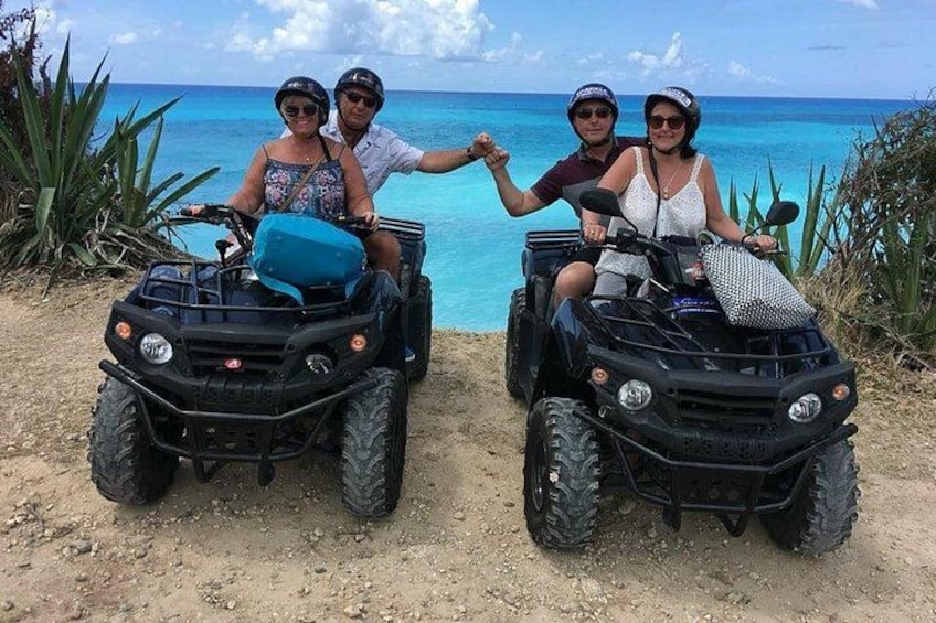 Deux personnes sur des quads, sur une plage de sable, avec l’océan en arrière-plan. 4