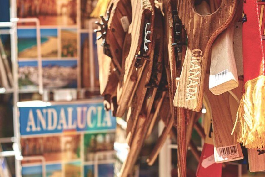 Des objets en bois portant des étiquettes, une enseigne indiquant « ANDALOUSIE », et un arrière-plan flou. 3
