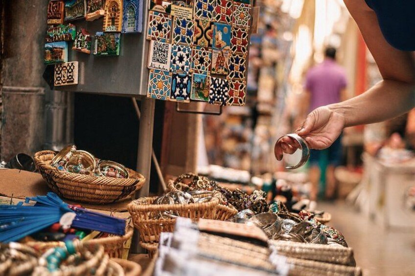 Un étal de marché où sont exposés divers articles, notamment des paniers tressés et des carreaux de faïence aux couleurs vives. 5