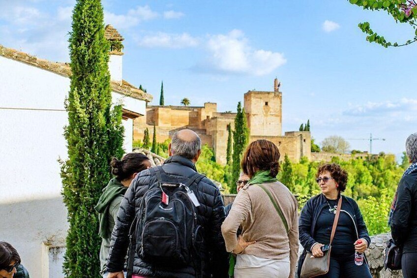 Un gruppo di persone che si ferma ad ammirare un edificio storico con una torre. 2