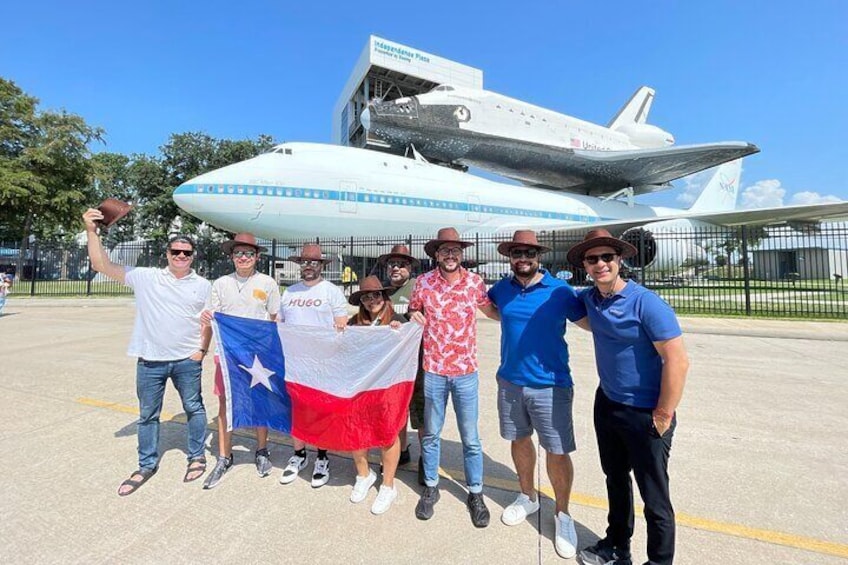 A group of people posing in front of a space shuttle. 5