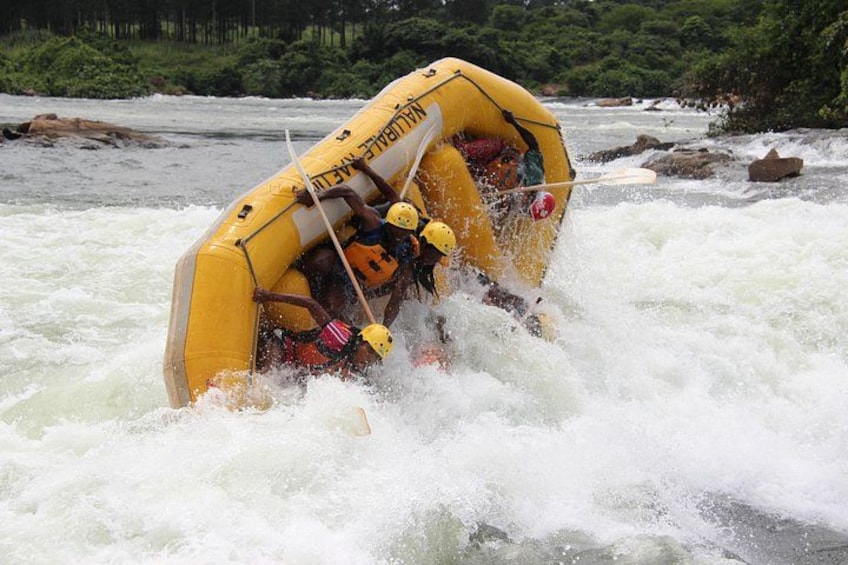 A yellow inflatable raft navigating turbulent river rapids. 1
