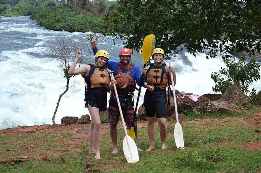 Three people kayaking on a river with rapids, wearing life jackets and helmets. 4