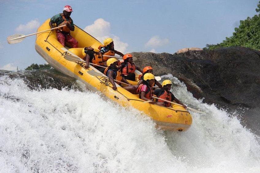 A group of people in a yellow raft navigating a river with white water rapids. 5