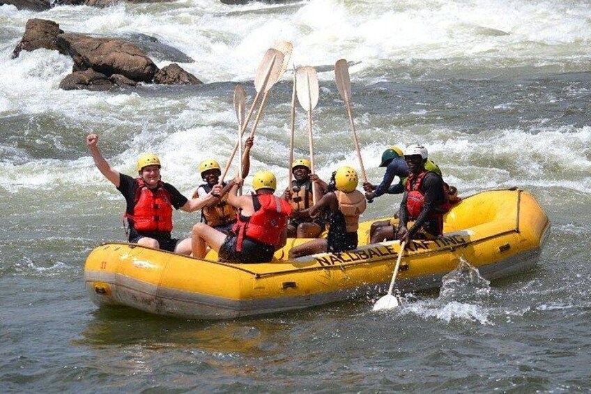 A group of people in a yellow raft on a river with rapids. 3