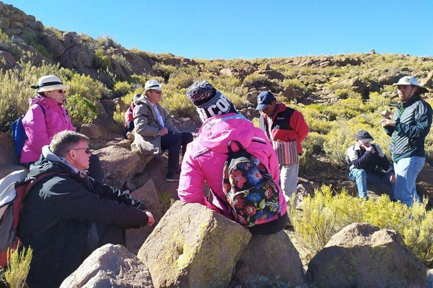 A group of people hiking in a rocky, hilly terrain with sparse vegetation. 1
