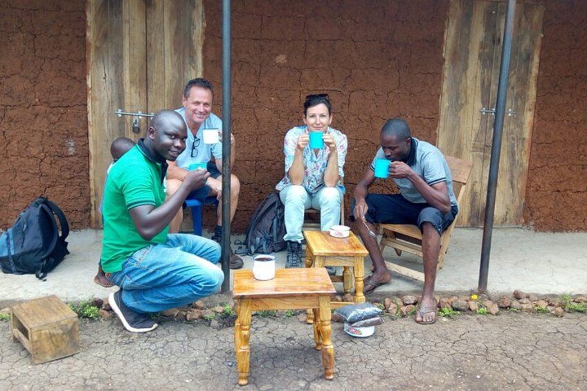 Four people sitting on chairs outside a building with a wooden table and a cup in front of them. 4