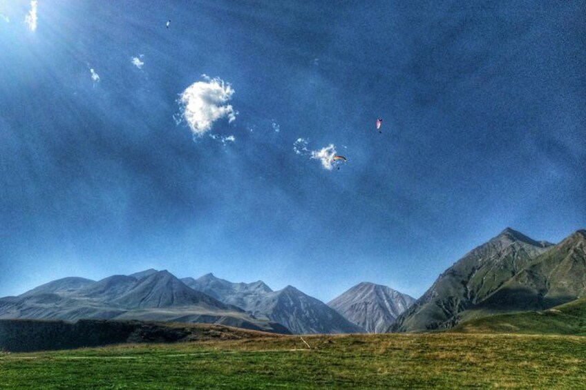 A mountainous landscape with a clear sky and a kite flying. 3