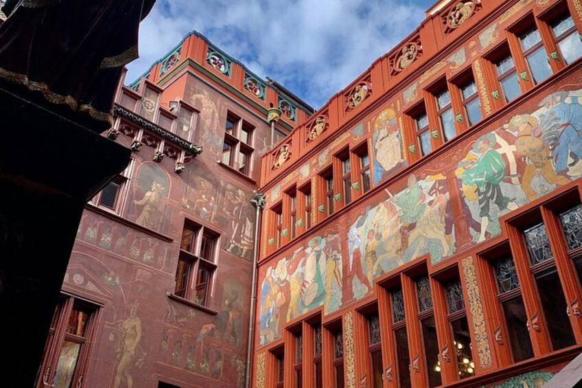 A building with detailed frescoes and ornate window frames. 3